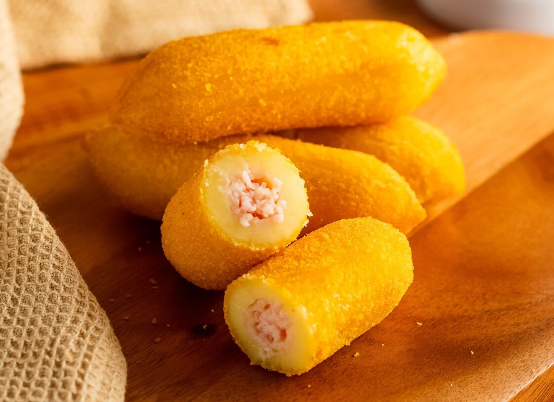 Enrolado de presunto e queijo frito aberto mostrando recheio – Vó Linda Casa de Salgados
