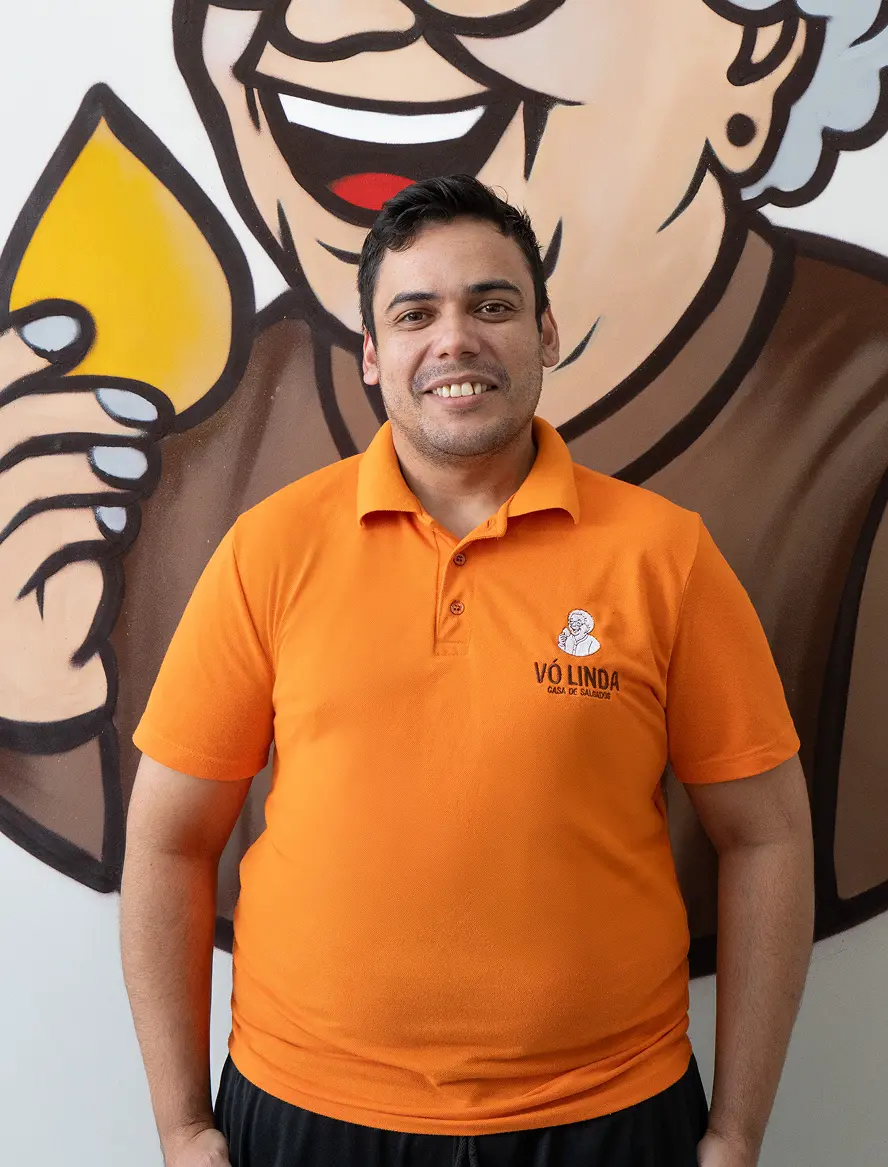 Leodir, fundador da Vó Linda Casa de Salgados, com uniforme laranja da marca em Maringá PR